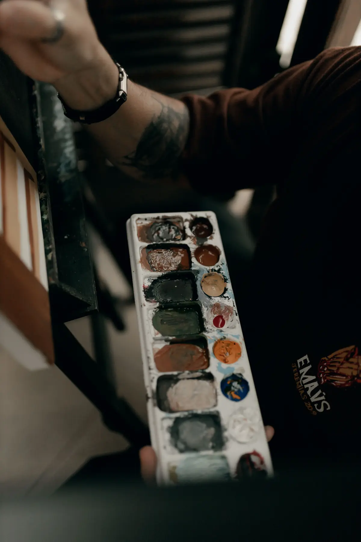 Manos sujetando una paleta con pintura