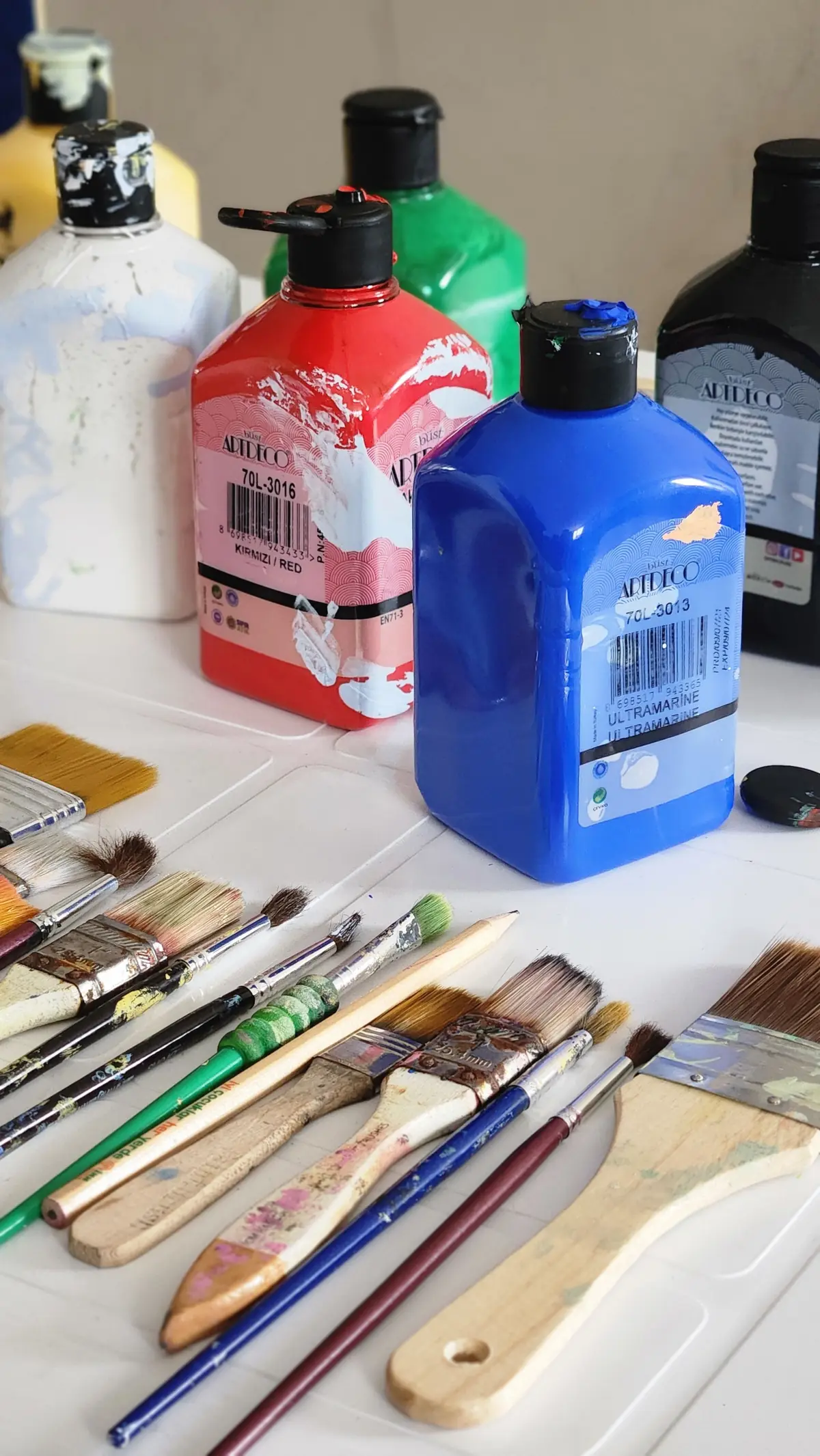 Botes de pintura y pinceles sobre una mesa