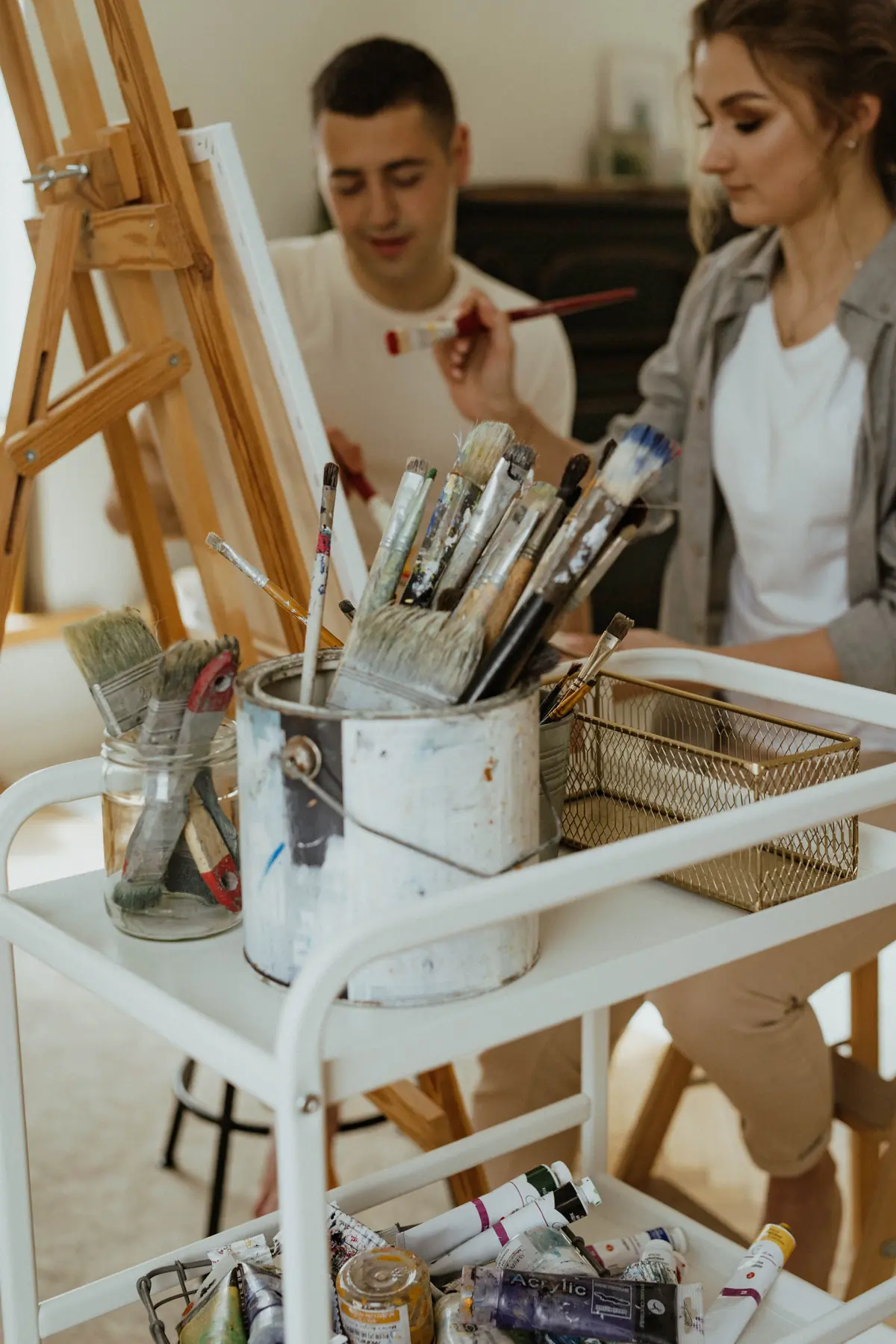 Pinceles y botes de pintura en una mesa de taller